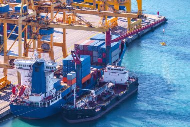 Denize giden gemi konteynırlarına yükleniyor, boşaltılıyor deniz limanının konteyner terminalinde vinç var.