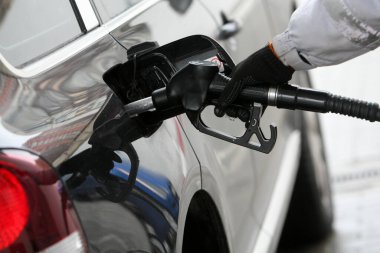 Gaz eklemek için yakıt hortumunu tutan el. Benzin istasyonunda yakıt ikmali. Yakıt, enerji, ekoloji kavramı.