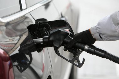 Gaz eklemek için yakıt hortumunu tutan el. Benzin istasyonunda yakıt ikmali. Yakıt, enerji, ekoloji kavramı.