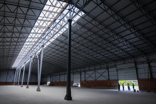 A huge metal construction warehouse. Grain dryer and threshing floor. Blurred-unrecognizable faces of people. Concept theme is the production of food and agricultural production.