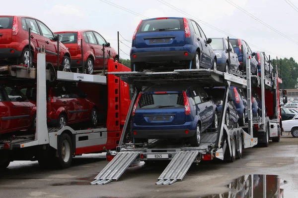 A new vehicles on transport car carrier truck - Heavy duty auto transporter trailer.