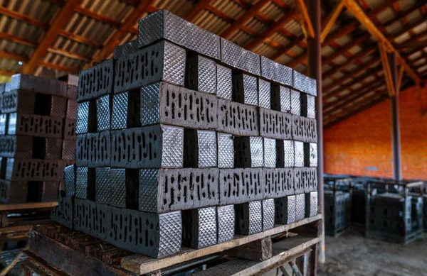 Production of clay bricks at a brick factory. Molded bricks stacked on pallets are dried before being sent to the kiln for firing.