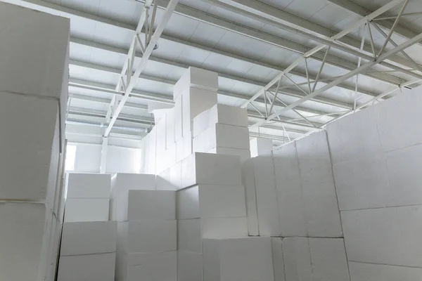 Industrial production of polystyrene foam insulation panels or plates from expanded polystyrene. A large blocks of Styrofoam are stacked in a warehouse. Building materials.