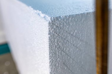 Sanayi yapımı polistiren köpük yalıtım panelleri veya plakalar. Büyük bir köpük bloğu otomatik bir makinede sıcak sicimler ile plakalara ayrılır. Bir inşaat malzemesi üretimi.