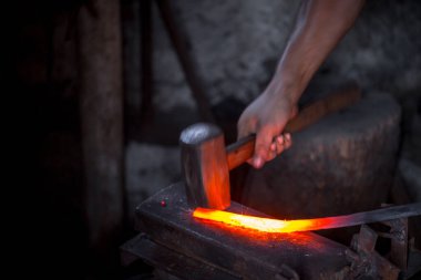 Demircinin elleri iş başında. Bir elinde çekiç, diğer elinde sıcak metalden bir iş parçası. Usta düzenli olarak örse vuruyor. Eski el sanatlarının sıkı çalışmasına bir örnek..