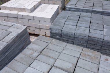 Baskılı çimento harcından endüstriyel yapı malzemeleri üretimi. Kaliteli kaldırım taşları. Filme yüklenmiş paletler üzerindeki bitmiş ürünler gönderilmeyi bekliyor.