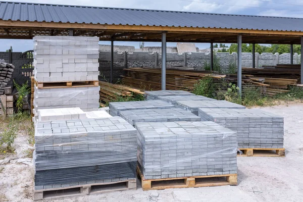 Industrial production of building materials from pressed cement mortar. High quality paving stones. Finished products on pallets packed in film are waiting to be shipped.