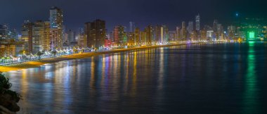 Sahili ve ünlü gökdelenleri olan yazlık tatil köyünün nefes kesici panoramik manzarası. Büyük şehrin güzel gece ışıkları. Costa Blanca 'da. Benidorm, Alicante, Valencia, İspanya.