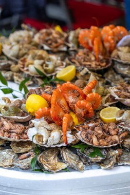 İstiridye, salyangoz, karides, karides ve istiridye de dahil olmak üzere çeşitli taze deniz ürünleri içeren büyük bir deniz ürünleri tabağı, pazarın çeşitliliğinin bir sunumu ve Fransa 'nın Paris kentinde bir tatma setidir..