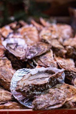 Taze istiridyeler Fransa 'nın Paris kentindeki bir deniz ürünleri pazarında satılıktır. Bir istiridye açık, içindeki et ortaya çıkıyor..