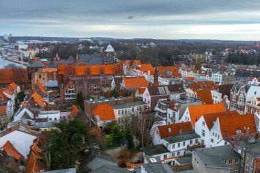 Almanya 'nın kuzeyinde Schleswig-Holstein eyâletinde, ortaçağ Lubeck' inin batı kısmının görüntüsü. Fotoğrafta terracotta çatısı ve arkasında Trave Nehri olan eski binalar var..