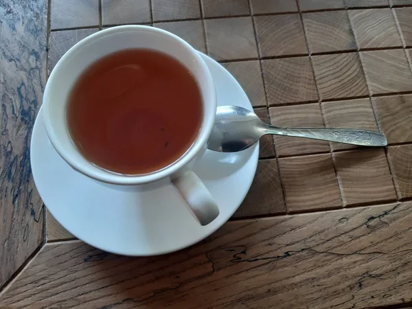 Filiżanka herbaty z łyżeczką na stole w kawiarni — Zdjęcie stockowe