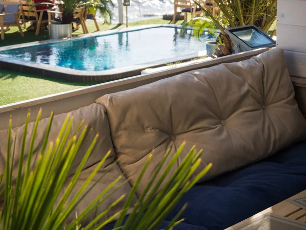 Sofá macio e mesa em um café ao ar livre com piscina — Fotografia de Stock