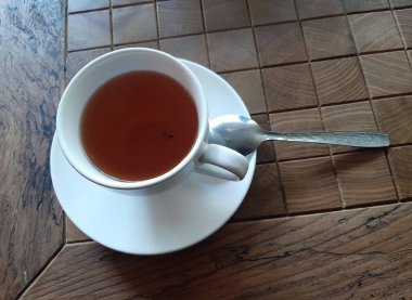 Bir kafede tahta bir masada bir çay kaşığı ile bir fincan çay. Rusya Soçi 05.04.2019