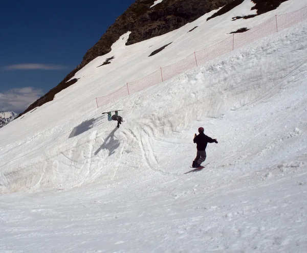 Snowboarder robi skok, podczas gdy jego przyjaciel robi zdjęcia z niego. Rosja Soczi 05.11.2019 — Zdjęcie stockowe