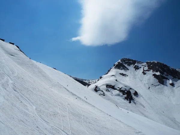 Rocky Mountains estância de esqui Gorky-gorod. Esquiadores na montanha. Traço de nuvem de metiorite. Rússia Sochi — Fotografia de Stock