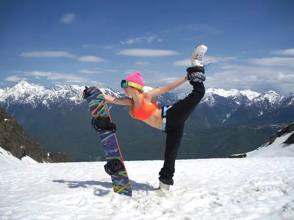 Hermosa chica snowboarder hace un hermoso salto en el fondo de las montañas en la estación de esquí Gorky-gorod. Rusia Sochi 05.11.2019 —  Fotos de Stock