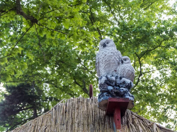 Statuette of two owls on background of green leaves. Park Riviera. Russia Sochi 06 05 2019 — Stock Photo, Image