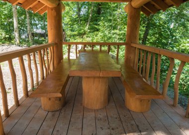 Bir masa ve günlük kabin büyük masif ahşaptan yapılmış iki banklar