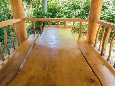 Bir masa ve günlük kabin büyük masif ahşaptan yapılmış iki banklar