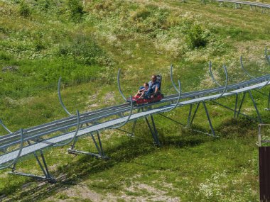 Baba ve oğul Rodelbahn'a biniyor. Rosa Khutor. Yükseklik 1100 m. Rusya Soçi 08 04 2019
