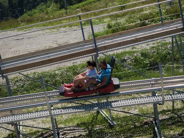 Karı koca Rodelbahn üzerinde neşeli binmek. Rosa Khutor. Rusya Soçi 08 04 2019