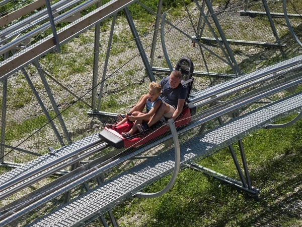 Baba ve oğul Rodelban'da yüksek hızda saça binerler. Rosa Khutor. Yükseklik 1100 m. Rusya Soçi 08 04 2019