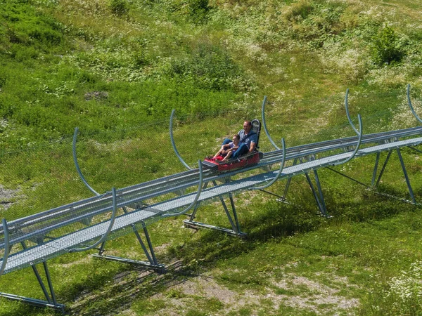 Baba ve oğul Rodelbahn'a biniyor. Rosa Khutor. Yükseklik 1100 m. Rusya Soçi 08 04 2019