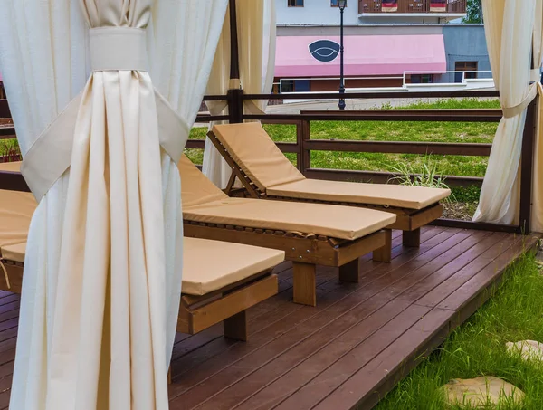 Wooden sunbeds for relaxing in the park at Rosa Khutor — Stock Photo, Image