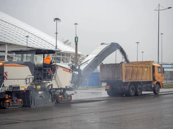 Studená frézka nakládá rozdrcený asfalt do skládkového vozu za oblačného počasí — Stock fotografie