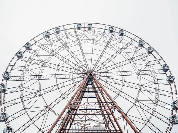 Foto De baixo para cima de uma roda gigante moderna alta com cabines fechadas contra um céu nublado . — Fotografia de Stock