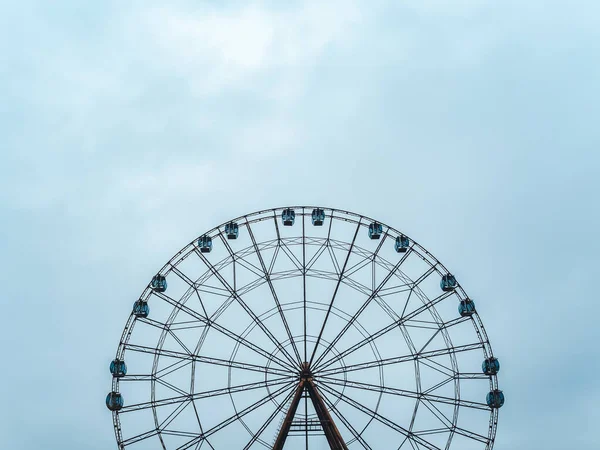 Roda gigante moderna alta com cabines fechadas em um fundo de céu azul — Fotografia de Stock