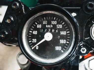 Eski bir Sovyet motosikletinin yuvarlak siyah hız göstergesinin yakın plan fotoğrafı.
