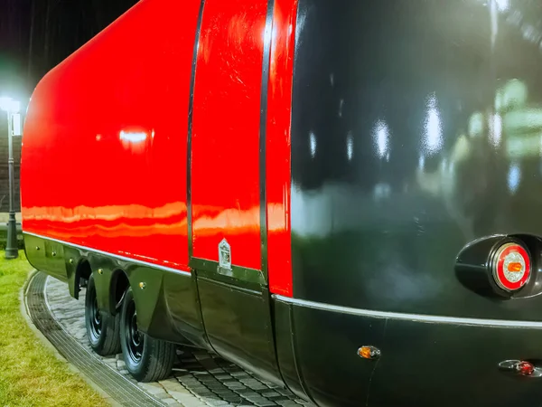 The side of the food truck is red and black on wheels and without windows at night — Stock Photo, Image