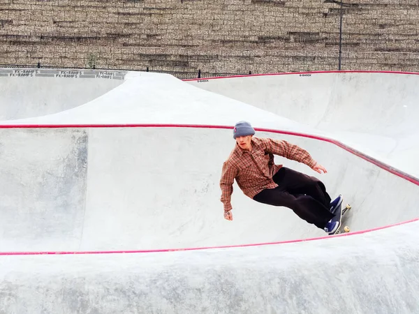 The guy rides a skateboard on the steep side of the rollerdrome — Stock Photo, Image