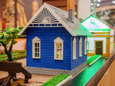 Gri çatılı ve beyaz pencereli mavi minyatür ev