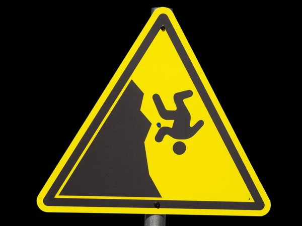 Żółty trójkątny znak z mężczyzną spadającym z urwiska na czarnym tle — Zdjęcie stockowe