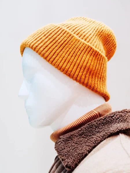 Профиль белого мужчины-манекена в оранжевой вязаной шляпе на белом фоне — стоковое фото