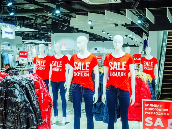Sochi, Ryssland - 14 december 2019. Vita skyltdockor i röda T-shirts med REA inskription stå i rad inne i butiken — Stockfoto