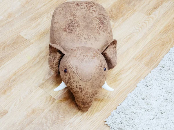 Giocattolo in morbida pelle elefante marrone con zanne bianche sul pavimento — Foto Stock