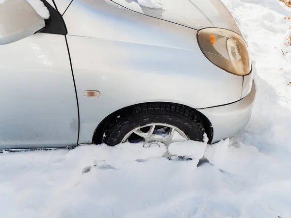 Framför en silverbil som fastnat i en snödriva — Stockfoto