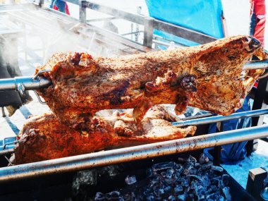 Kavrulmuş bir koç gövdesi kömürün üzerinde tükürük parlak güneş tarafından aydınlatılır.