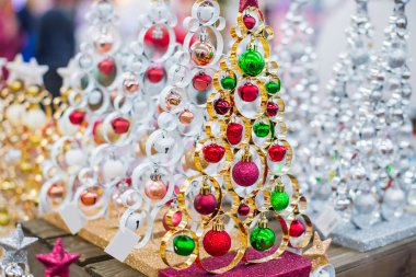 Dekoratif metalik gümüş ve altın modern dantelli Noel ağaçları ile kopya alanı için metin ışık bokeh zemin üzerine ahşap masa üzerinde kırmızı ve yeşil toplar. Seçici odak