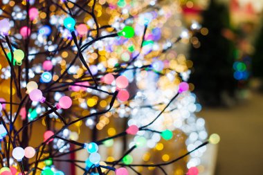 Ağaç şekli garland çeşitli parlak Noel ışıkları dükkanda arka plan üzerinde renkli ampul ışıkları kapatın. Tatil arka plan. Xmas tatil dekorasyon Pazar. Seçici odak. kopya alanı