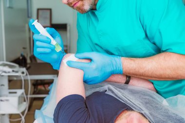 Nörolog Doktor yakından bir enjeksiyon tedavisi (abluka) dirsek eklem erkek hasta kasına yapar. Alternatif ağrı tedavi kavramı. Seçici odak, metin için yer