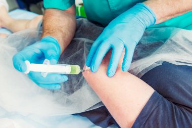 Nörolog Doktor yakından bir enjeksiyon tedavisi (abluka) dirsek eklem erkek hasta kasına yapar. Alternatif ağrı tedavi kavramı. Seçici odak, metin için yer