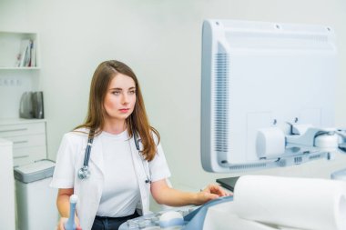 Ciddi, konsantre genç doktor, barışsever test etmek için ultrason tarama makine kullanarak uzman. Uzay kopyalayın. Seçici odak