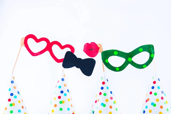 Carnival caps and funny masks on a white background isolated. Party tools and decoration. Happy birthday layout. Purim. Design concept. Select focus, Copy space