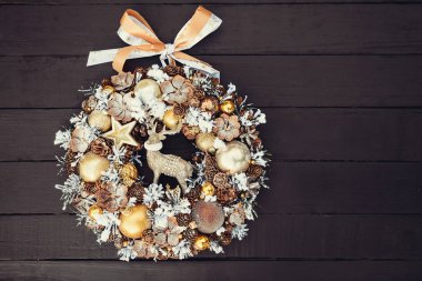 Çam kozalakları, süsbitkileri, çam dalları, toplar, yıldız ve siyah ahşap zemin, düz yatıyordu üzerine dekoratif geyik üstten görünüm güzel el yapımı altın Noel çelenk süslenmiş. Kopya alanı