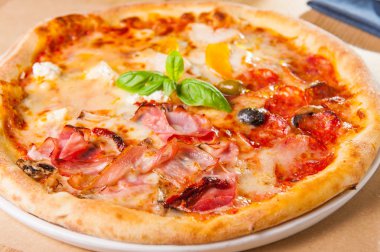 Seçici odak kapatmak lezzetli et Pizza domuz pastırması ve sosis ahşap masa üzerinde beyaz tabakta çatal ve malzemelerle